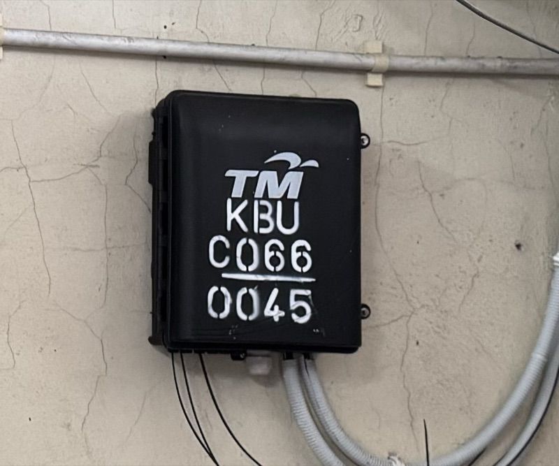 Example of a TM DP box on a wall, with the TM logo and a code